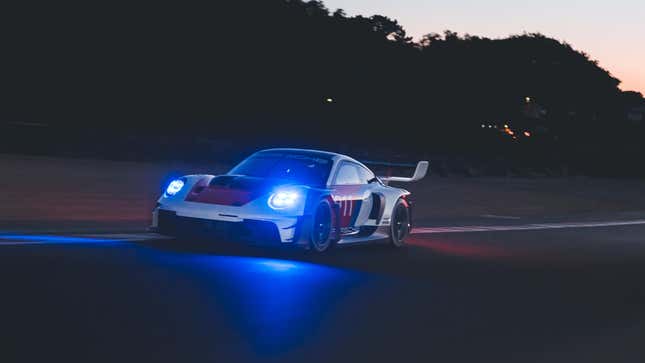 Der 911 GT3 R Rennsport fährt nachts mit strahlend blauen Scheinwerfern auf die Kamera zu
